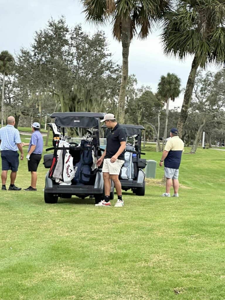 May be an image of 4 people, people golfing, golf cart and golf course